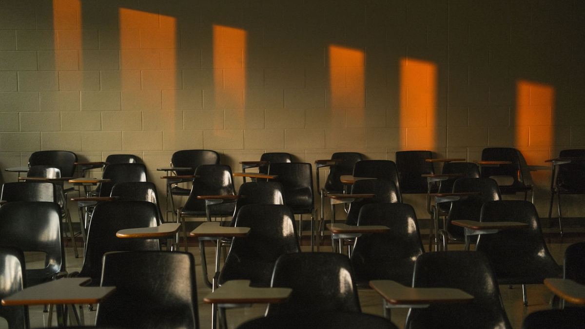 An empty classroom with rows of desks in late afternoon light