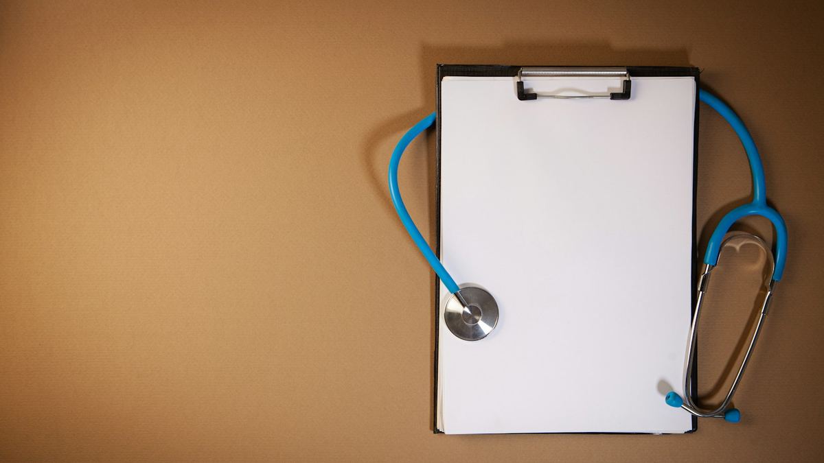 A clipboard and stethoscope on a desk