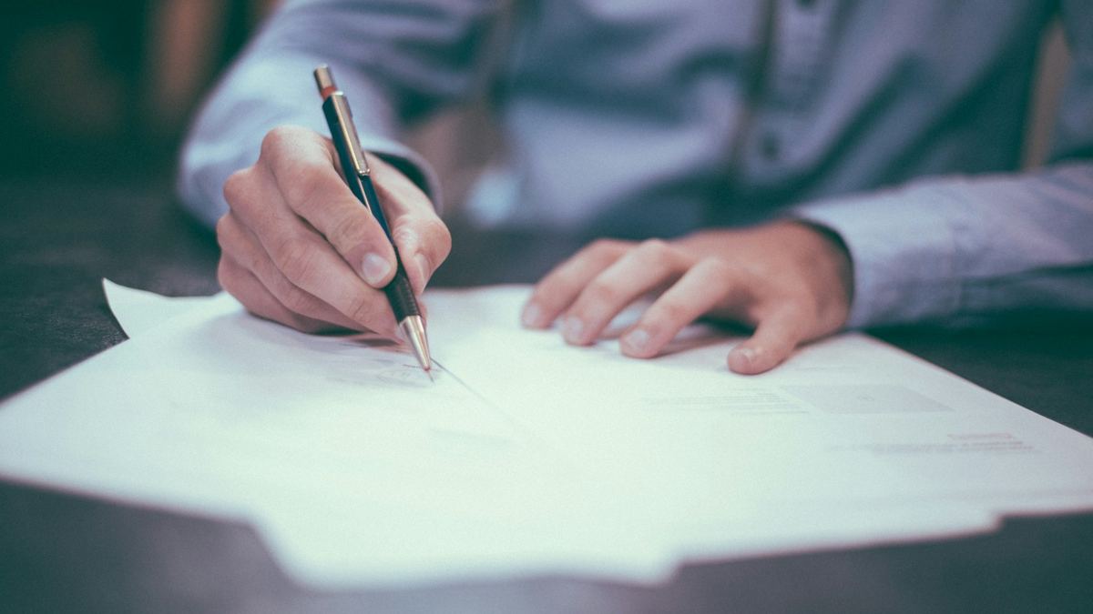 A hand writing on a printed document