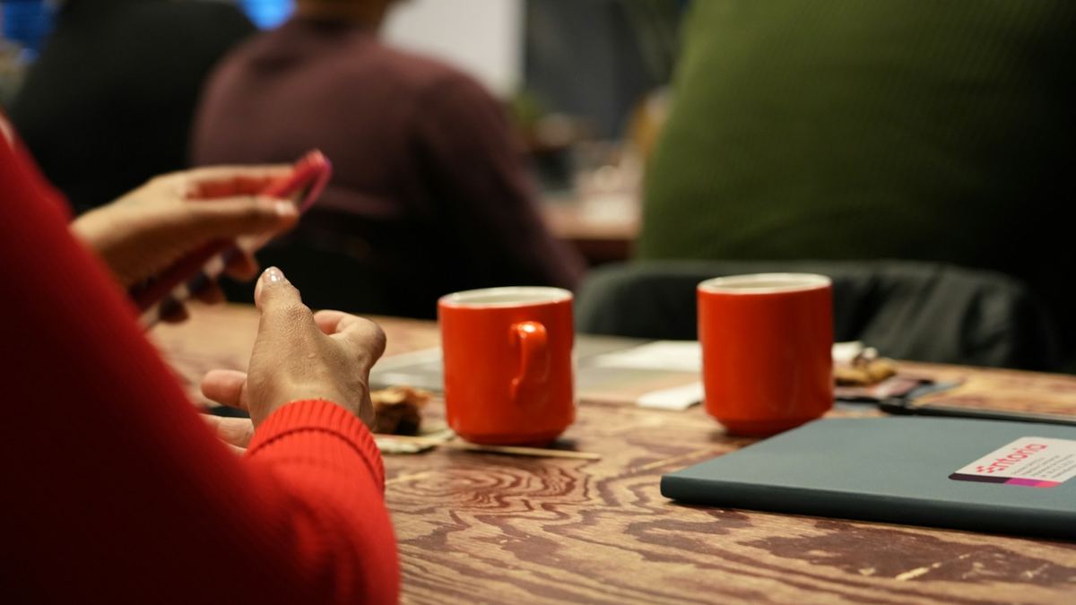 Two mugs on a wooden table during a conversation