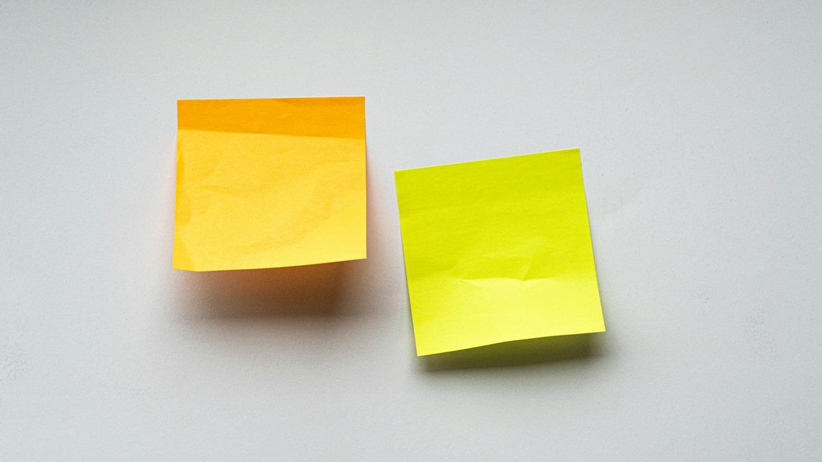 Two blank sticky notes on a pale surface